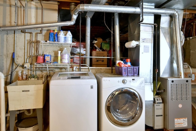 laundry room with laundry area, independent washer and dryer, and a sink