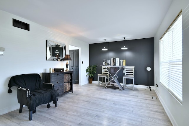 living area featuring light wood-style flooring and baseboards