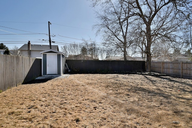 view of yard featuring a fenced backyard, an outbuilding, and a storage shed