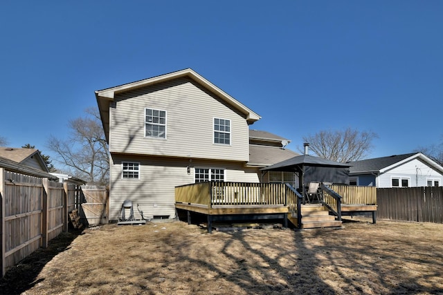 rear view of property with a fenced backyard and a wooden deck