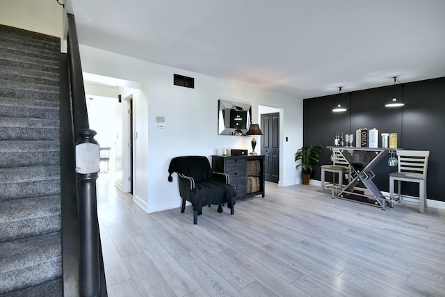 interior space with stairway, visible vents, light wood-type flooring, and baseboards