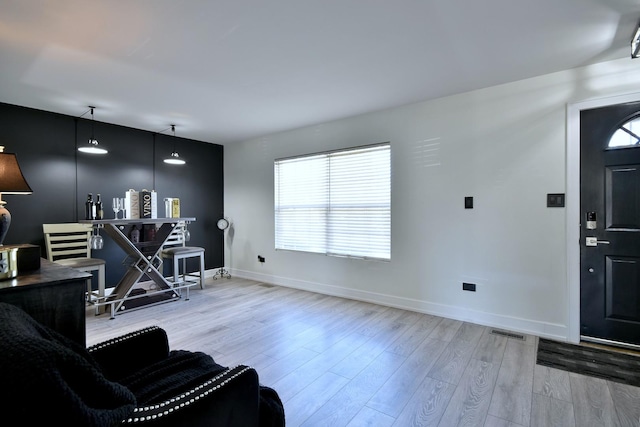 living area with visible vents, wood finished floors, and baseboards