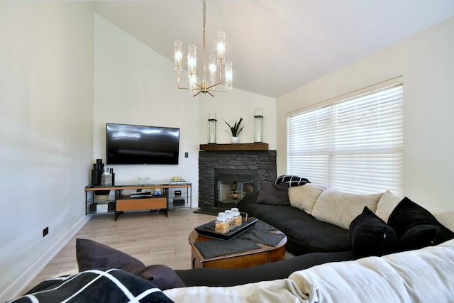 living room featuring baseboards, a fireplace, an inviting chandelier, light wood-style floors, and high vaulted ceiling