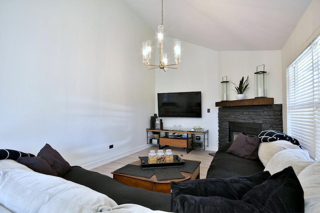 living room with a stone fireplace, lofted ceiling, light wood-type flooring, and a chandelier