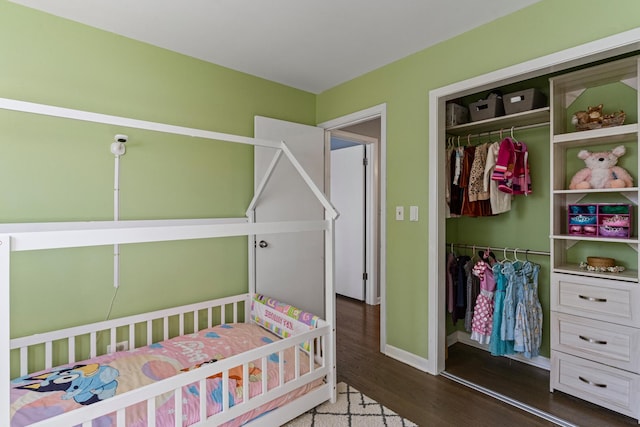 bedroom featuring a closet, baseboards, and wood finished floors