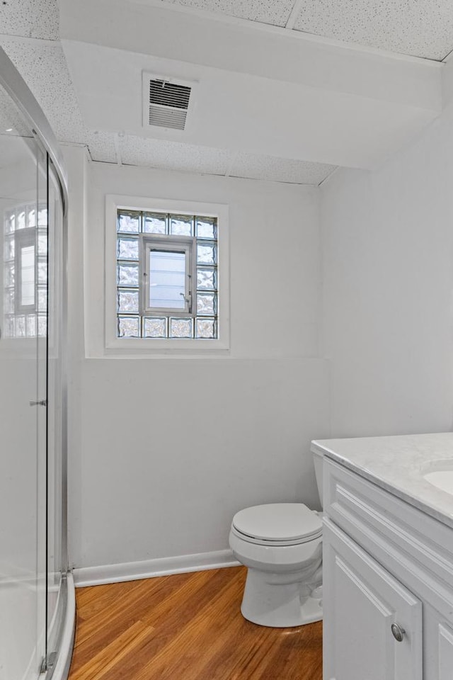 full bathroom with toilet, wood finished floors, visible vents, and a paneled ceiling