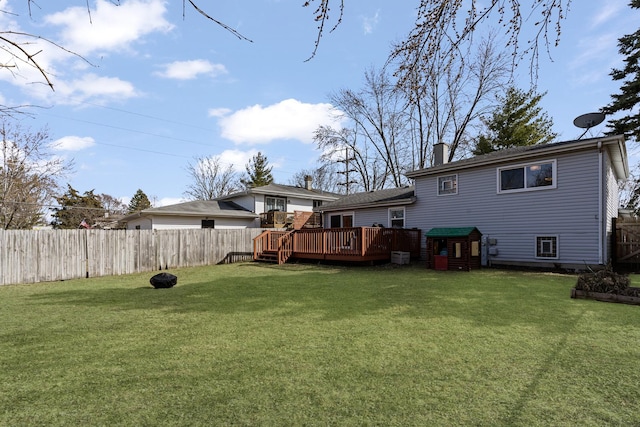 back of property with a yard, a chimney, and a fenced backyard