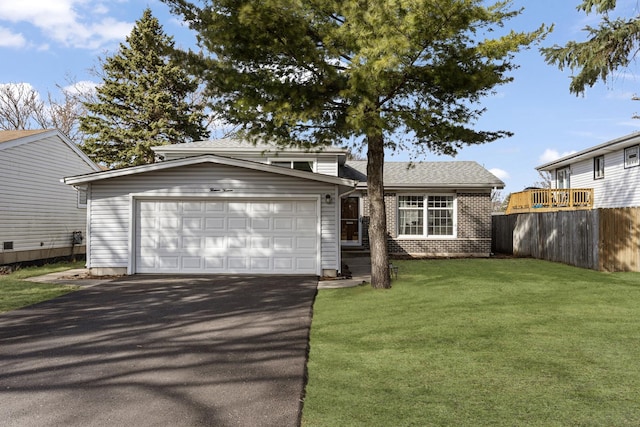 view of front facade featuring aphalt driveway, fence, a front yard, a garage, and brick siding