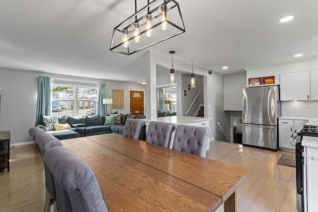 dining room featuring recessed lighting, stairway, baseboards, and light wood finished floors