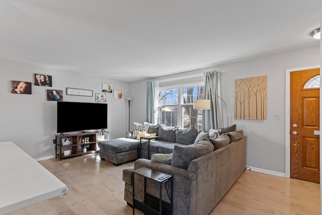 living area featuring light wood-style floors and baseboards