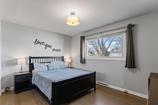 bedroom featuring wood finished floors, visible vents, and baseboards