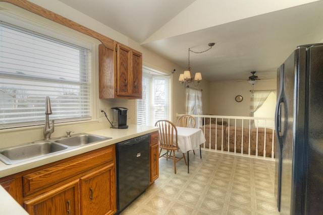 kitchen featuring black appliances, a sink, light countertops, light floors, and vaulted ceiling