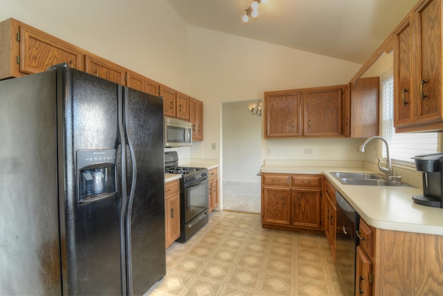 kitchen with brown cabinetry, light floors, black appliances, and a sink