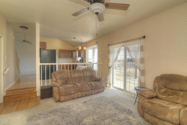 living area with carpet floors, ceiling fan, vaulted ceiling, and wallpapered walls