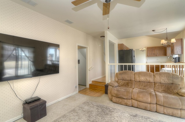 living room featuring wallpapered walls, baseboards, visible vents, and light colored carpet