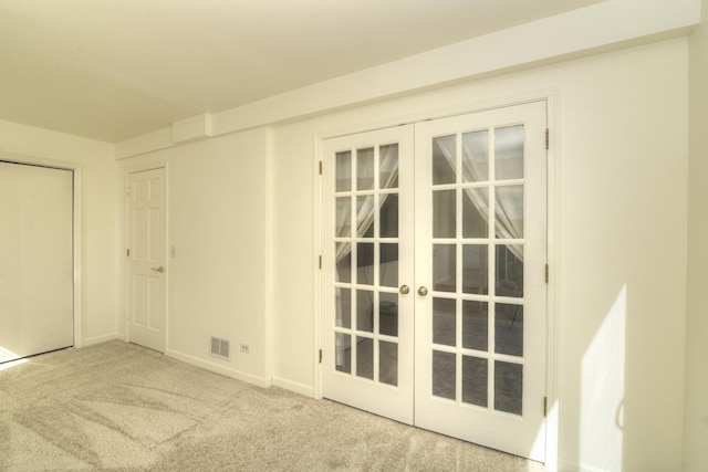 carpeted spare room with visible vents, french doors, and baseboards