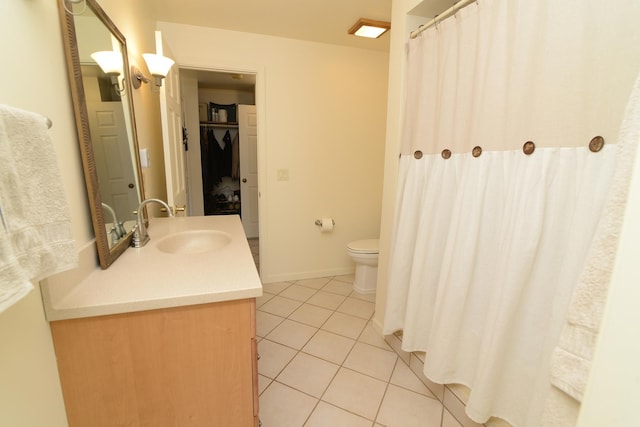 bathroom featuring tile patterned flooring, toilet, vanity, and baseboards