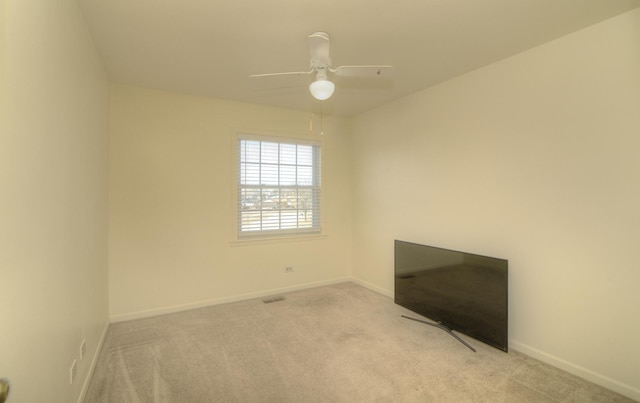 spare room featuring visible vents, baseboards, light colored carpet, and a ceiling fan