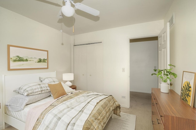 bedroom featuring light colored carpet, visible vents, a closet, and ceiling fan