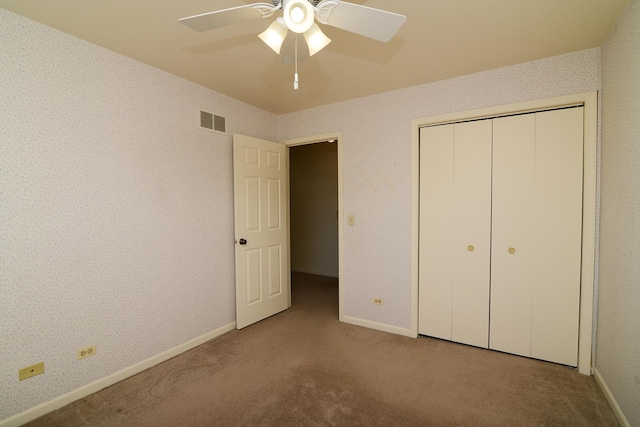 unfurnished bedroom featuring baseboards, visible vents, wallpapered walls, and carpet