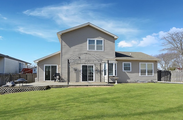 back of house with a lawn, a wooden deck, and fence