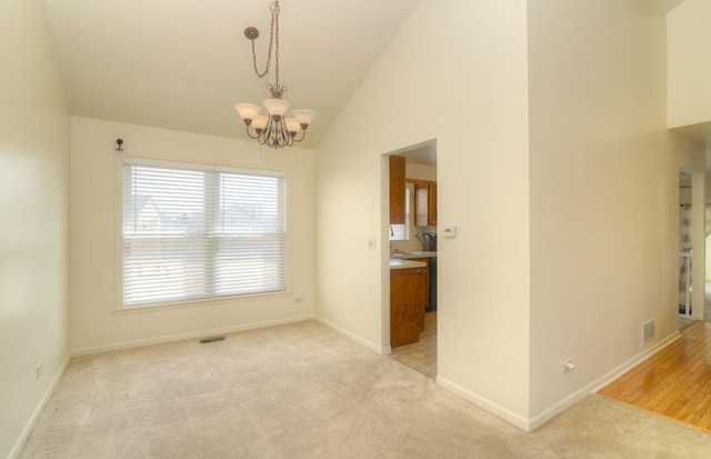 unfurnished dining area with visible vents, light carpet, baseboards, a chandelier, and vaulted ceiling