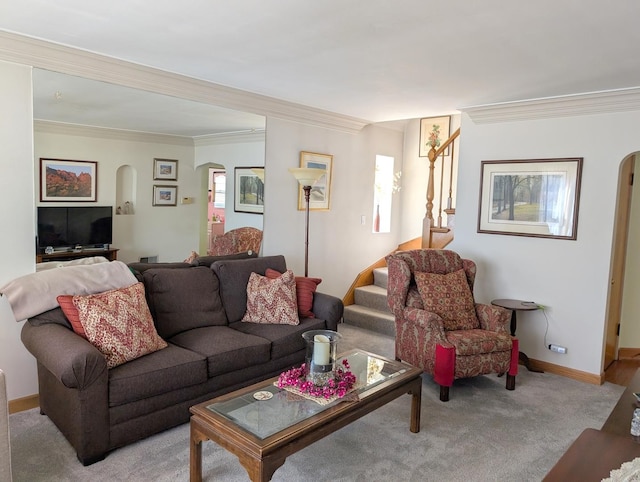 living room with baseboards, arched walkways, ornamental molding, and stairs