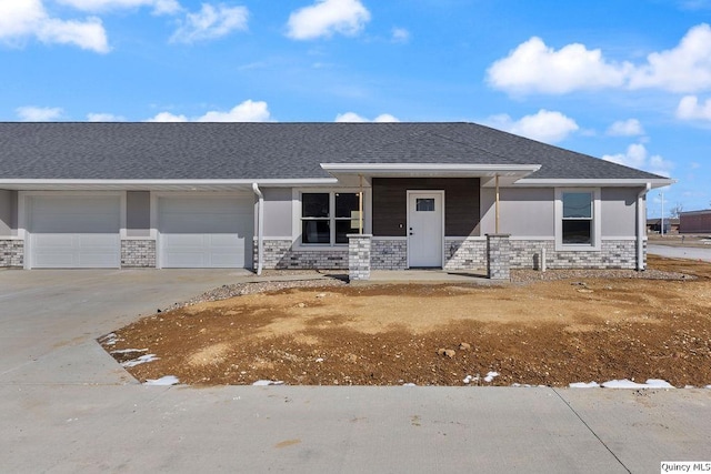 view of front facade with a garage, a porch, concrete driveway, and a shingled roof