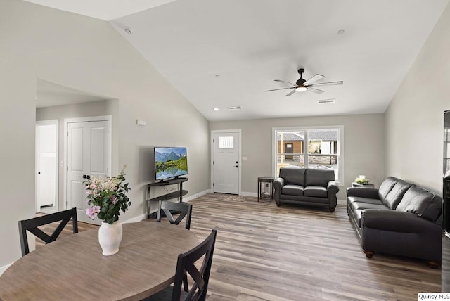 dining room with baseboards, visible vents, high vaulted ceiling, light wood-style flooring, and ceiling fan