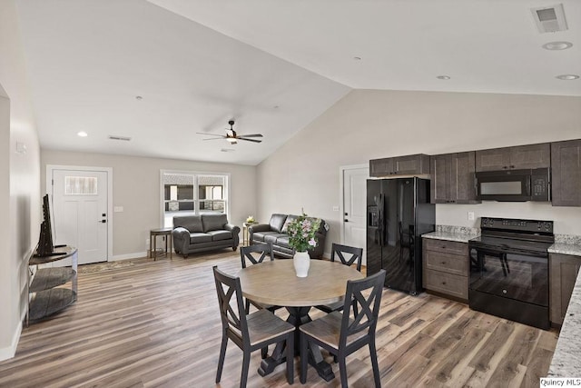 dining area with visible vents, lofted ceiling, baseboards, and light wood finished floors