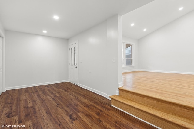 unfurnished room featuring recessed lighting, baseboards, wood finished floors, and vaulted ceiling