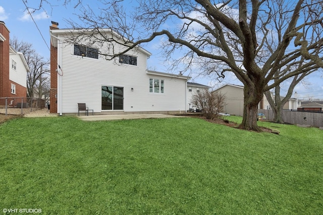 rear view of house with a patio area, a fenced backyard, a lawn, and a chimney