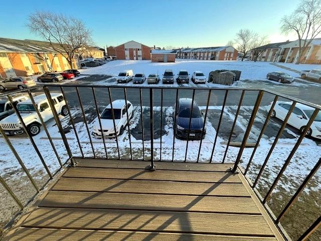 snow covered back of property with a residential view