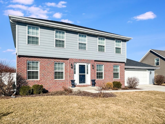 colonial house featuring a front lawn, a garage, brick siding, and driveway