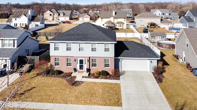 view of front of house featuring driveway, a residential view, an attached garage, a front yard, and brick siding