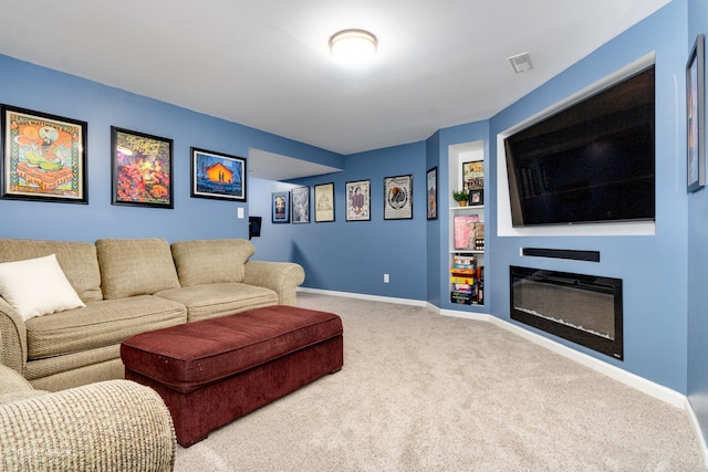 living room featuring a glass covered fireplace, baseboards, and carpet floors