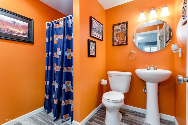 bathroom with a shower with curtain, toilet, and baseboards