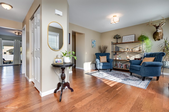 living area featuring baseboards and wood finished floors