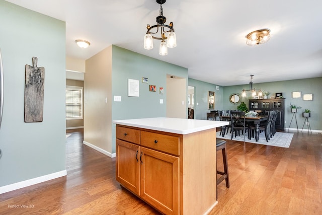 kitchen with a notable chandelier, light wood-style flooring, and pendant lighting