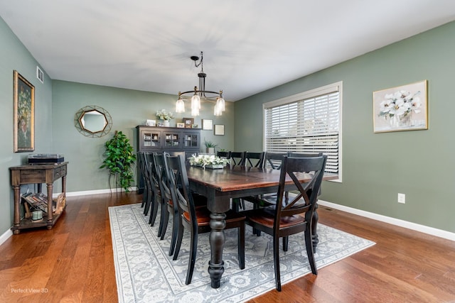 dining area with an inviting chandelier, baseboards, visible vents, and dark wood-style flooring