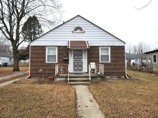 bungalow-style home featuring a front yard and fence