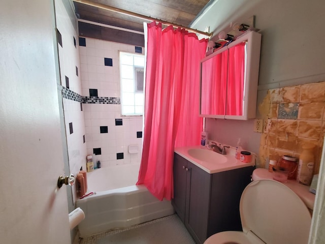 bathroom with toilet, tile walls, vanity, and shower / bath combination with curtain