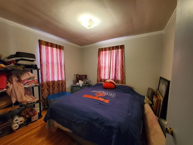 bedroom featuring crown molding and wood finished floors