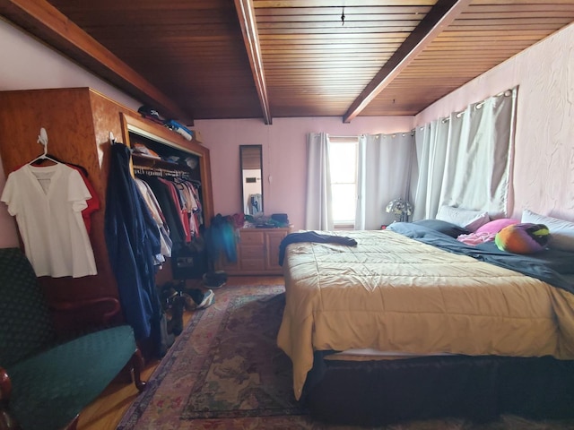 bedroom featuring beamed ceiling, wood ceiling, and a closet