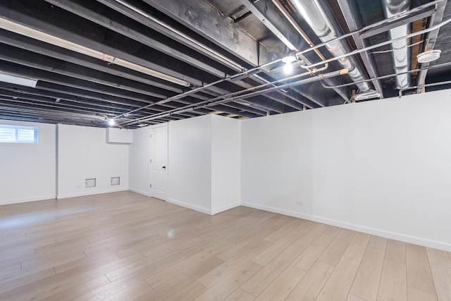 basement with baseboards and wood finished floors