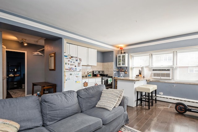 living area with cooling unit, dark wood-type flooring, and a baseboard heating unit