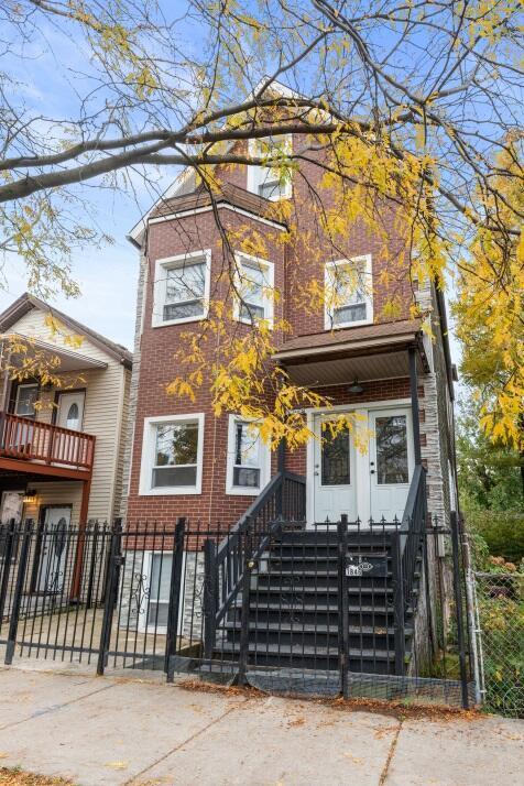 view of front of house featuring brick siding and a fenced front yard