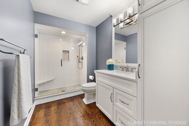 full bathroom with vanity, a stall shower, toilet, and wood finished floors