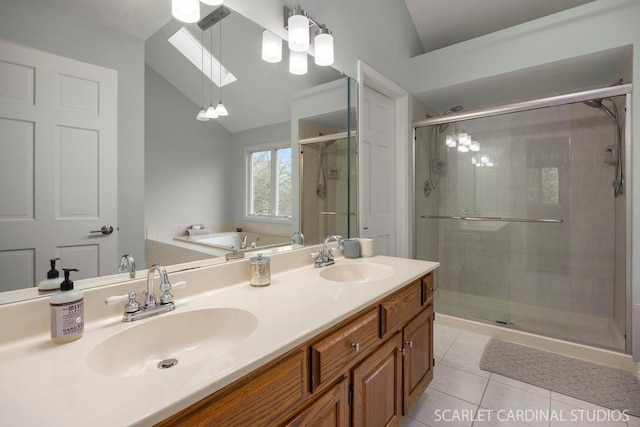 full bath with tile patterned floors, a sink, and vaulted ceiling with skylight