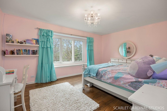 bedroom featuring baseboards, a chandelier, and wood finished floors